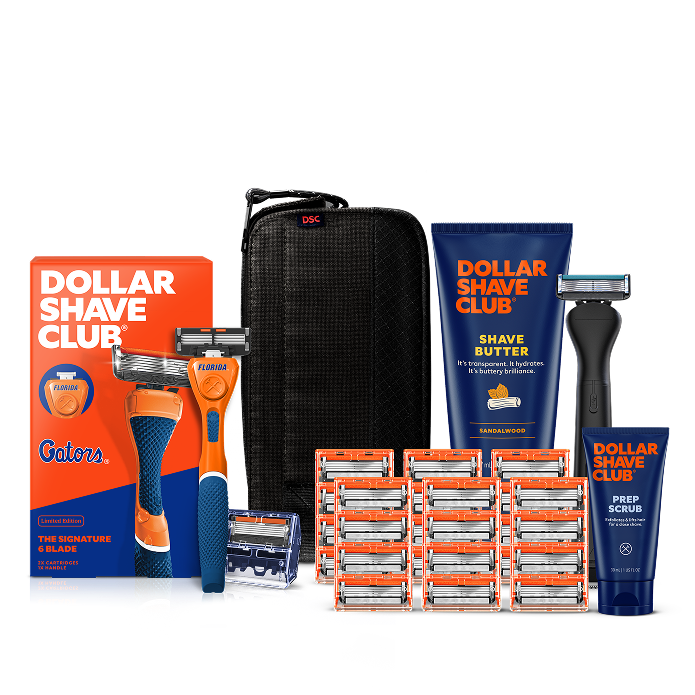 Dollar Shave Club University of Florida grooming kit on a white background. Includes a blue razor handle with the Florida logo, 24 blades, Shave Butter, Prep Scrub, a black 3-in-1 electric trimmer, and a black traveler case.