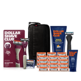 Dollar Shave Club Texas A&M University grooming kit on a white background. Includes a maroon razor handle with the Aggies logo, 24 blades, Shave Butter, Prep Scrub, a black 3-in-1 electric trimmer, and a black traveler case.
