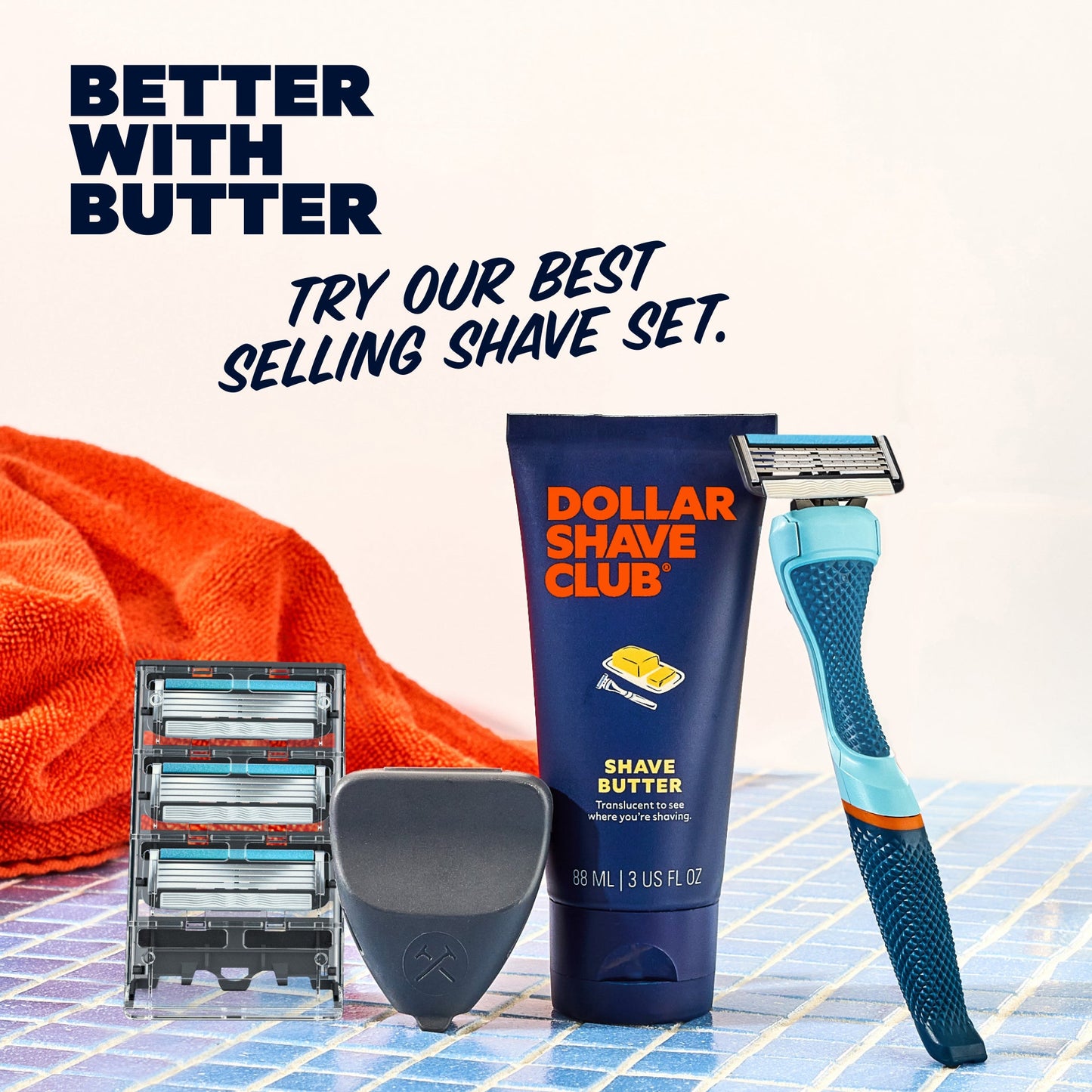 Shave set with razor, razor heads, and shave butter on a tiled surface.